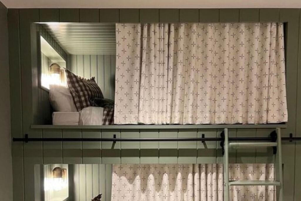 A Bunk bed for 2 havinf Bunk Bed Curtains, ladder and pillow