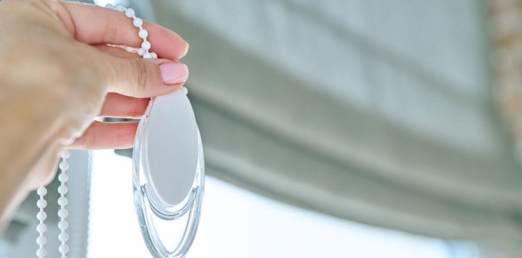 How Roman Blinds Work a person handling roman blinds