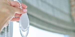 How Roman Blinds Work a person handling roman blinds